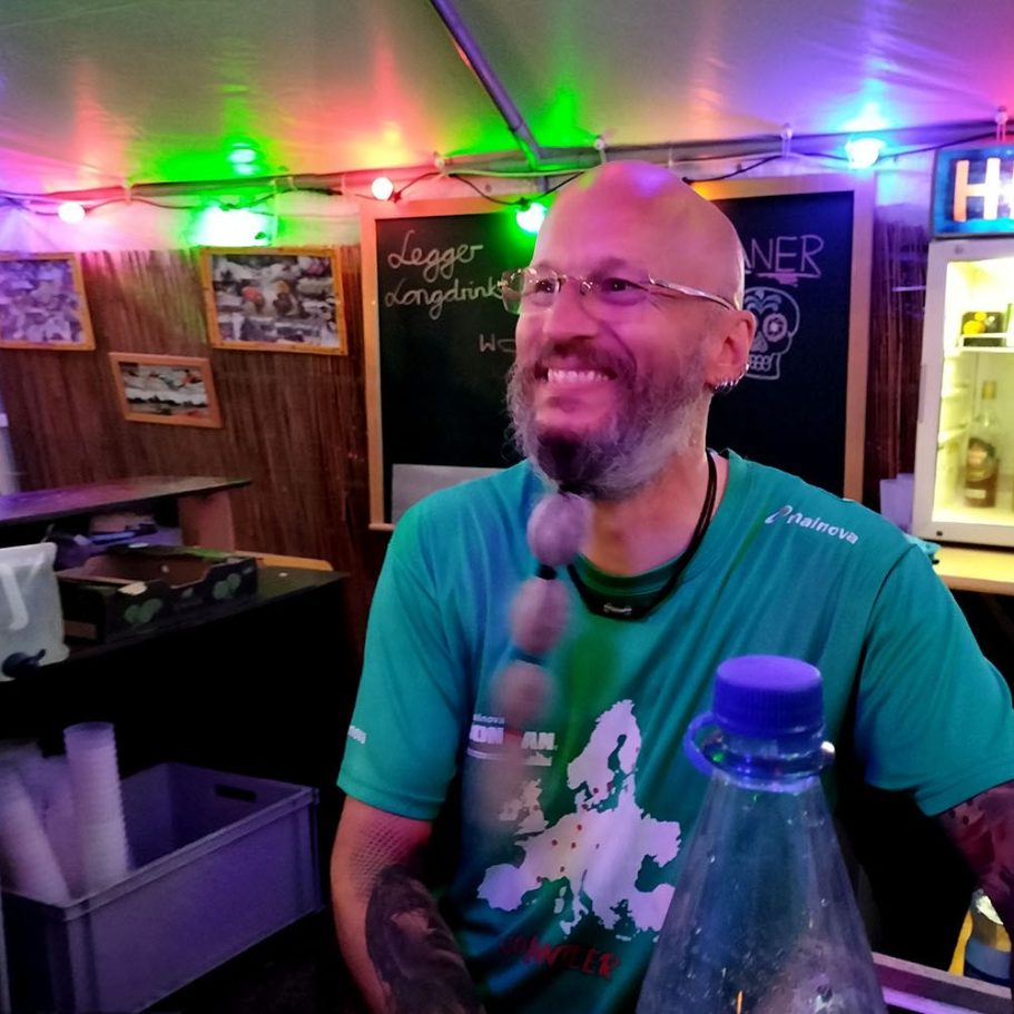 HKCW Stand beim Höchster Altstadtfest der Vereine Mann mit Brille und Bart, lächelt in einer bunten, beleuchteten Bar.